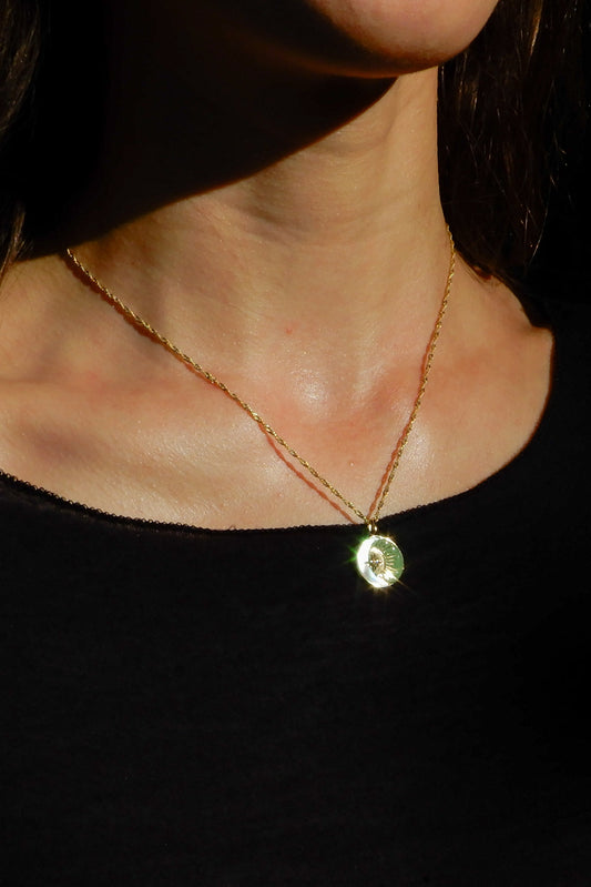 Necklace with a pendant worn by a person against a dark background