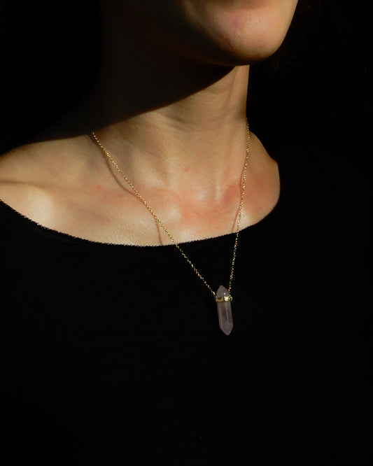 Necklace with a pendant worn by a person on a black background