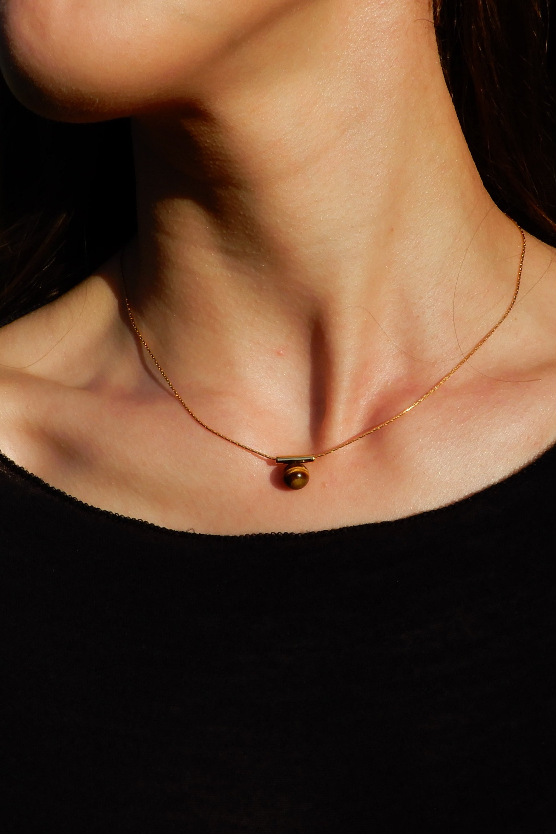 Necklace with a pendant worn by a person outdoors